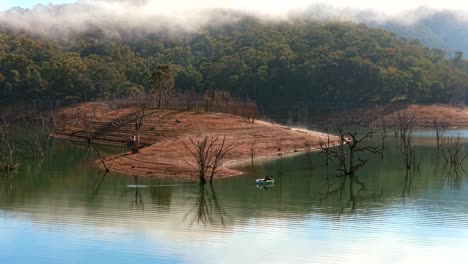 lake eildon fishing on a misty day drone pan shot