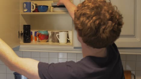 man in kitchen takes lunchbox from press