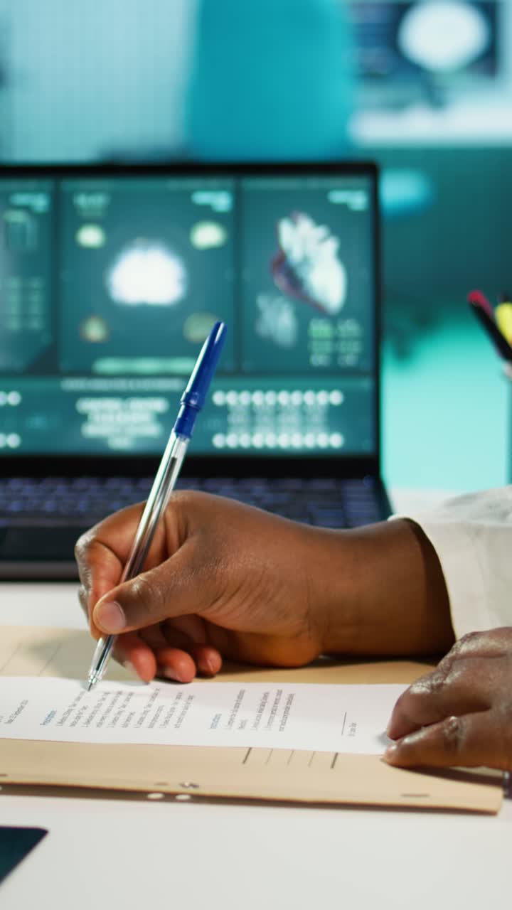 Professional Hands Writing on Document with Medical Scans on Laptop