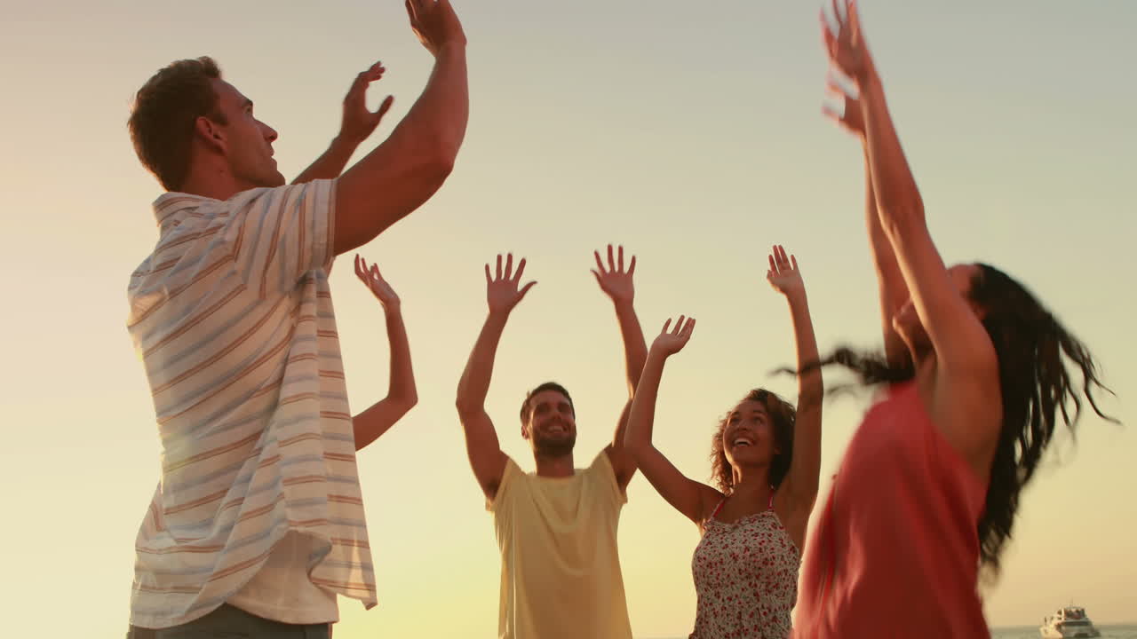 amigos jugando con una pelota en la playa