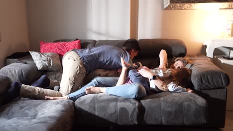 playful couple tickling and laughing on sofa