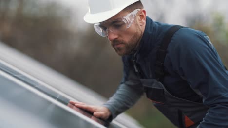 portret van een werknemer van een zonne-energiecentrale die een paneel inspecteert met een speciale bril op