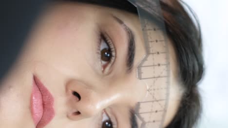 close-up of eyebrow mapping with a ruler for beauty treatment