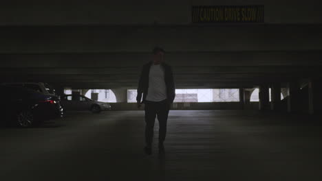 young caucasian male walking through a parking garage