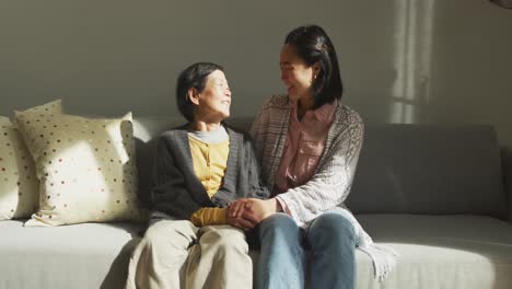 smiling senior asian woman with granddaughter embracing