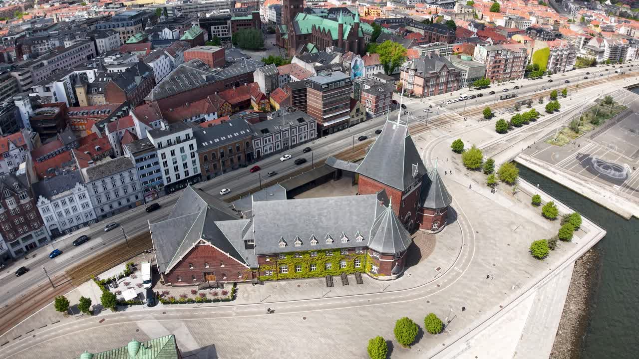 Aerial drone view of colorful historic European city buildings, narrow streets, and waterfront architecture on a sunny day