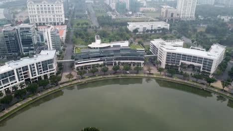 drone tilt up reveals condos and shopping center buildings at waters edge, vietnam