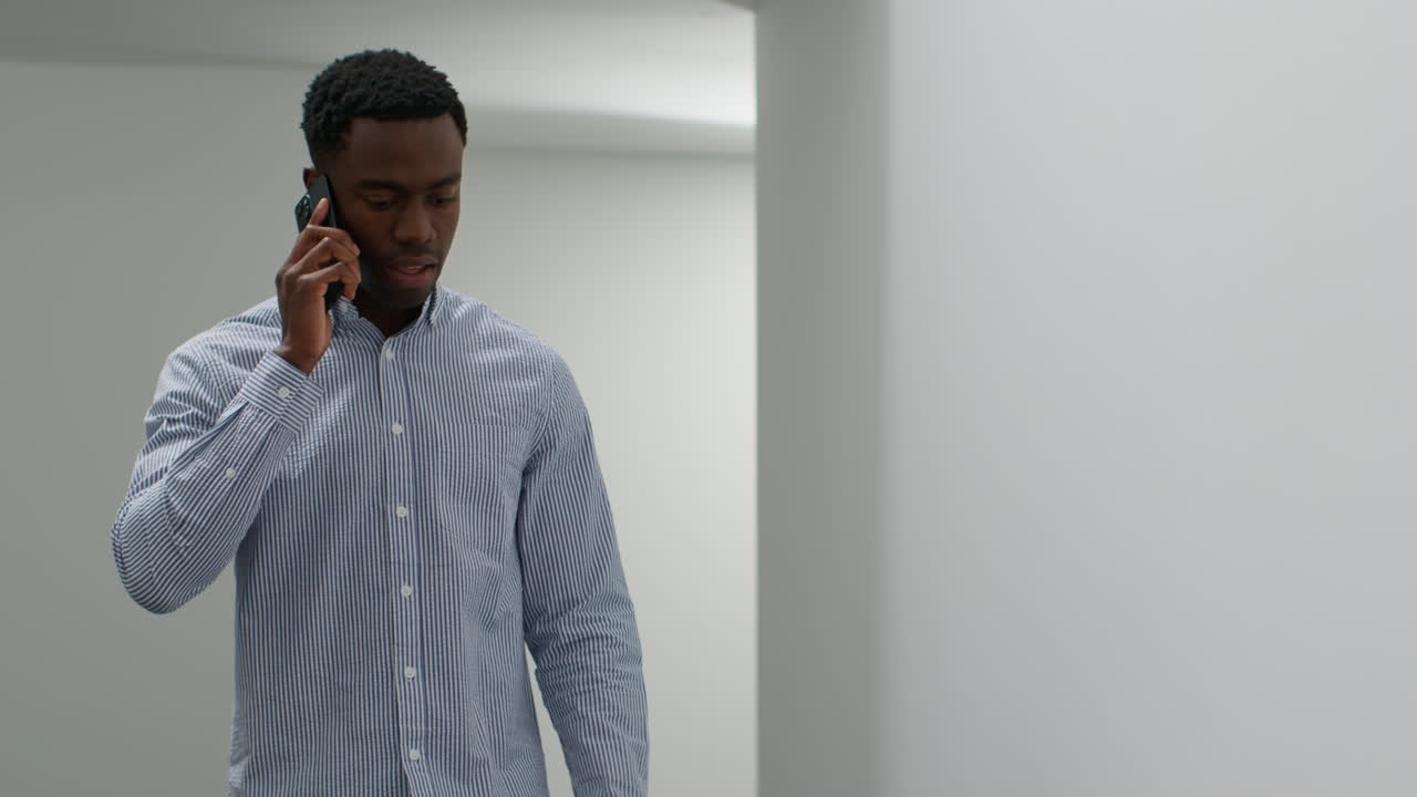 Young Businessman In Office Talking On Mobile Phone Looking Frustrated And Angry