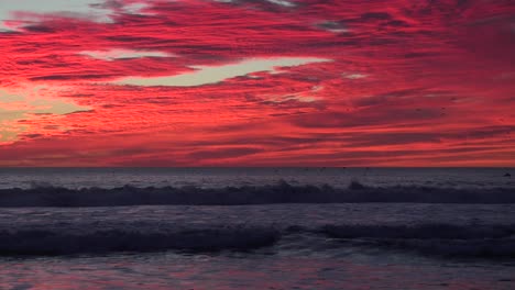 zoom zurück von einem blutroten sonnenuntergang enthüllt den kalifornischen ozean