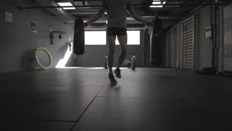 young athletic man skipping a rope at the gym