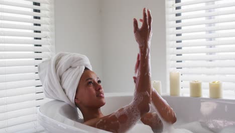 African-american-woman-bathing-in-the-bath-tub-in-the-bathroom-at-home