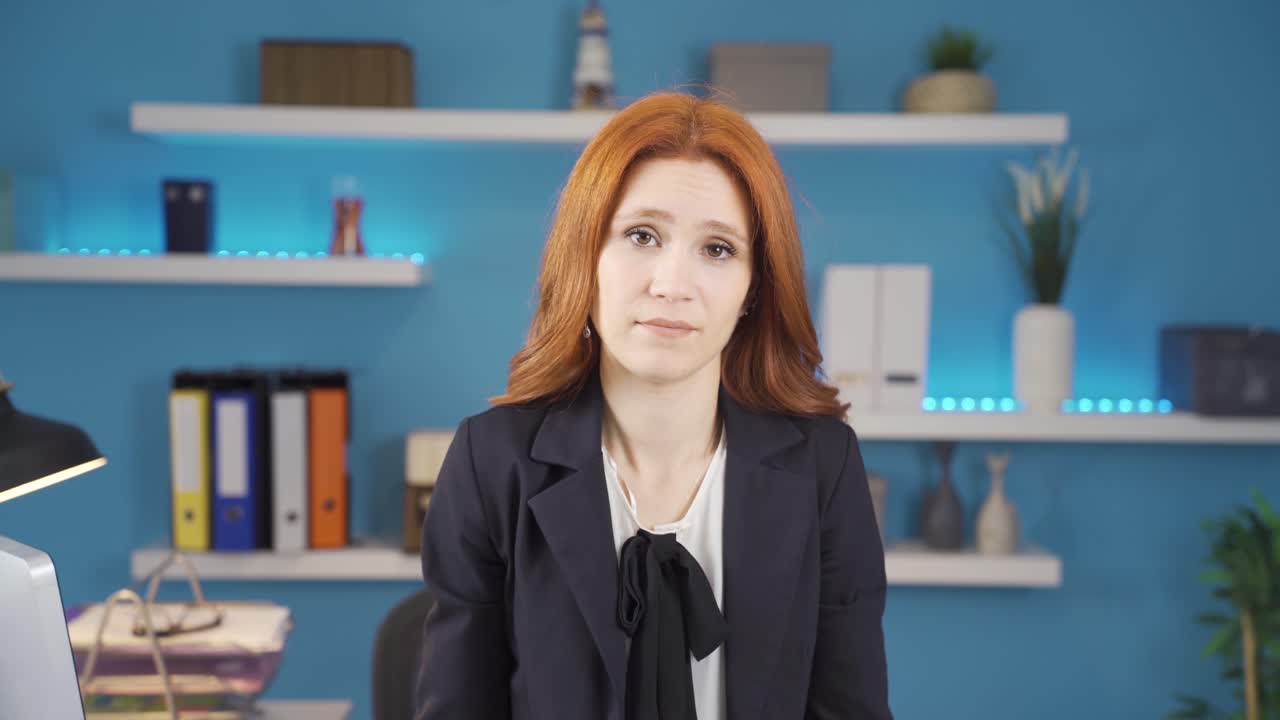 una mujer de negocios infeliz suspira mirando a la cámara.