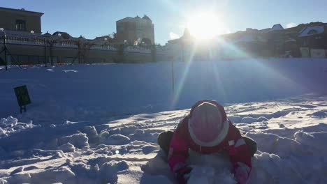 child playing winter funny game. girl playing with snow in sun weather