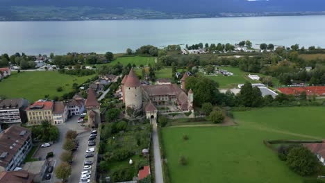 orbit drone shot of beautiful chenaux castle in estavayer-le-lac with lake neuchatel in fribourg switzerland