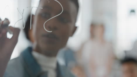 joven mujer de negocios afroamericana líder de equipo escribiendo en pizarra entrenando colegas compartiendo ideas de resolución de problemas en el seminario de presentación de la oficina