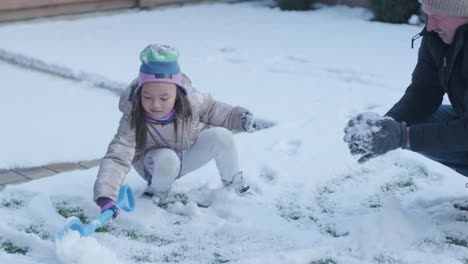 grandfather and granddaughter having fun in the snow