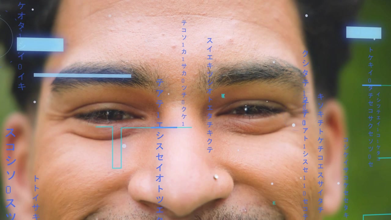 Man starting relaxed and smiling, eyes crinkling, blue HUD overlay aligning for technology demo