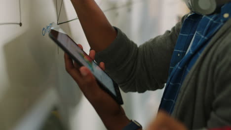 Team-Mit-Daten-Auf-Dem-Tablet-Beim-Whiteboard-Zeichnen