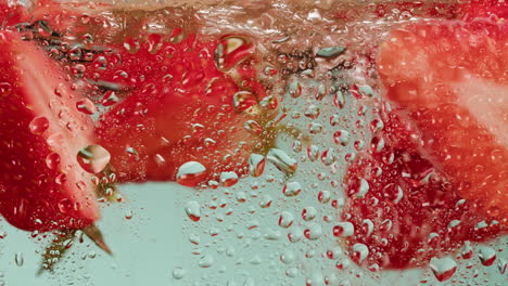 fresh strawberries in water with water drops