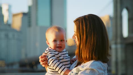 Mother-with-young-daughter-standing-by-bridge,-Manhattan