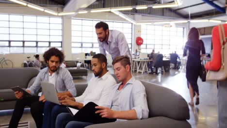 Business-executives-discussing-over-laptop