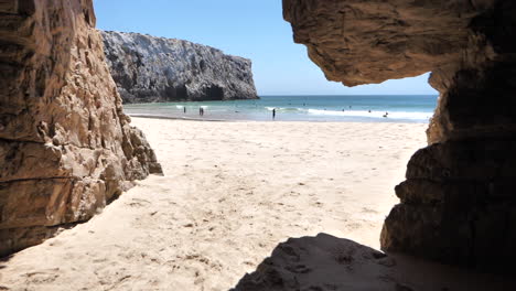 Walking-between-rocky-wall-towards-Sagres-beach-on-sunny-day