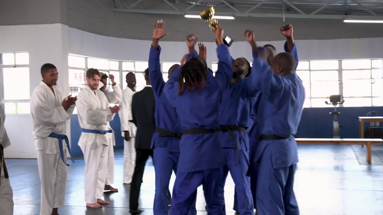 Practicing judo, group of athletes in blue uniforms training together indoors