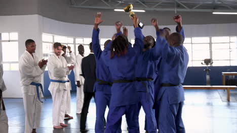 practicing judo, group of athletes in blue uniforms training together indoors