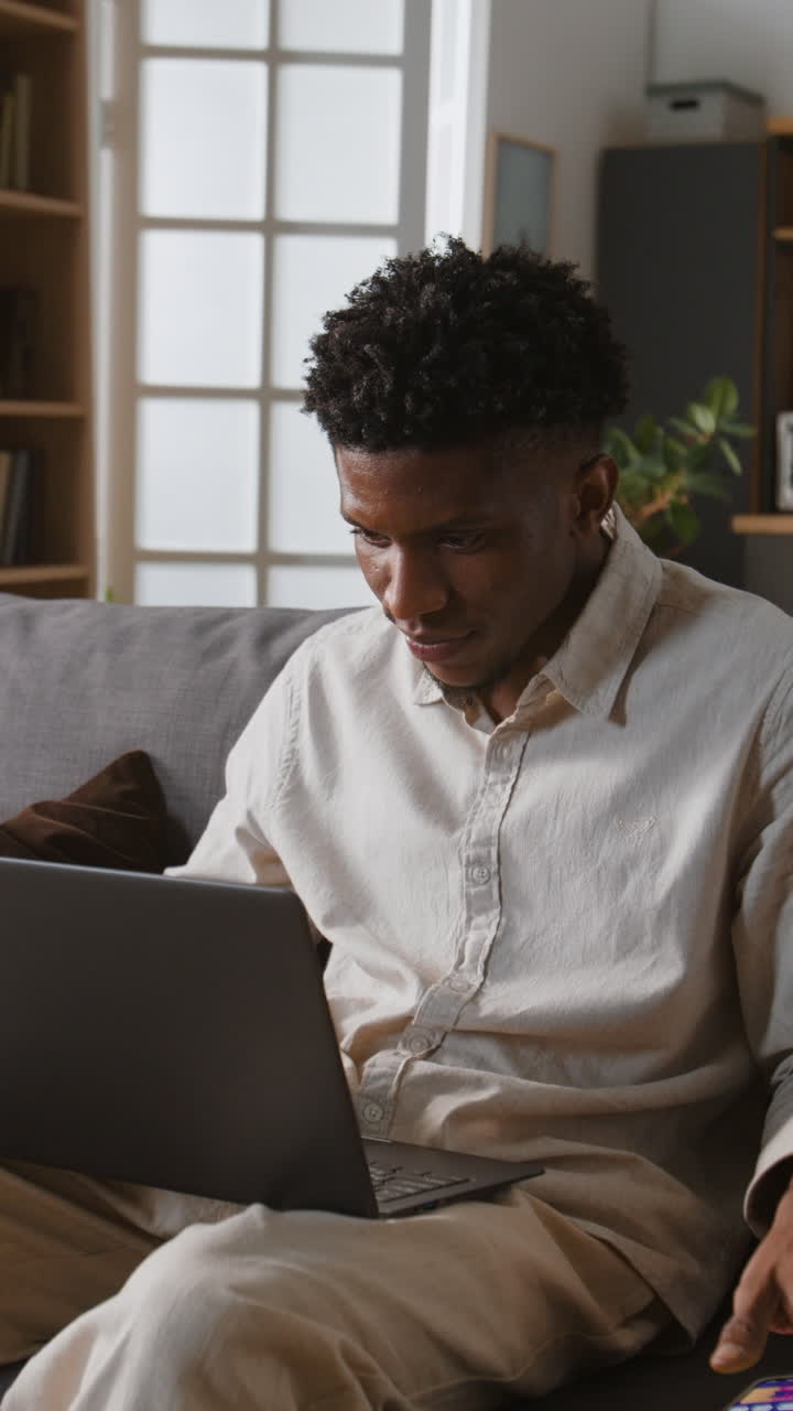 Man using laptop and smartphone at home