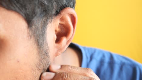 close-up of a person touching their ear