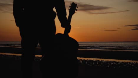 man running with guitar in back sand beach at sunset-28