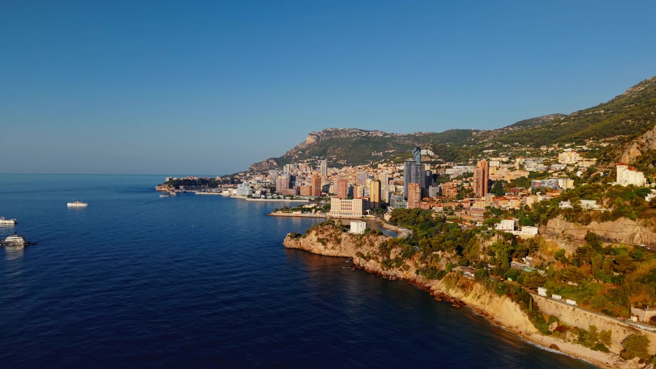 Vista aerea della costa di Montecarlo con edifici cittadini e barche al tramonto
