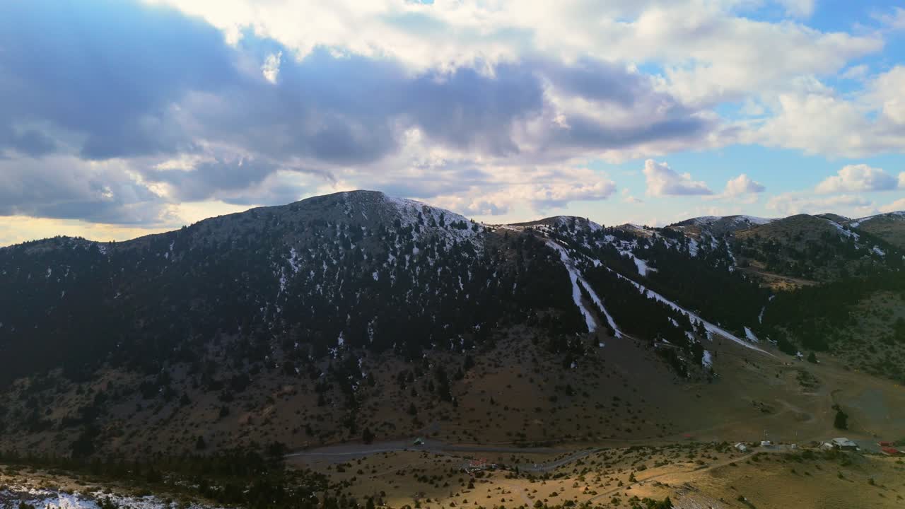establecimiento aéreo panorámico con rayo de luz de las montañas del peloponeso con nieve entre los árboles bajo las nubes