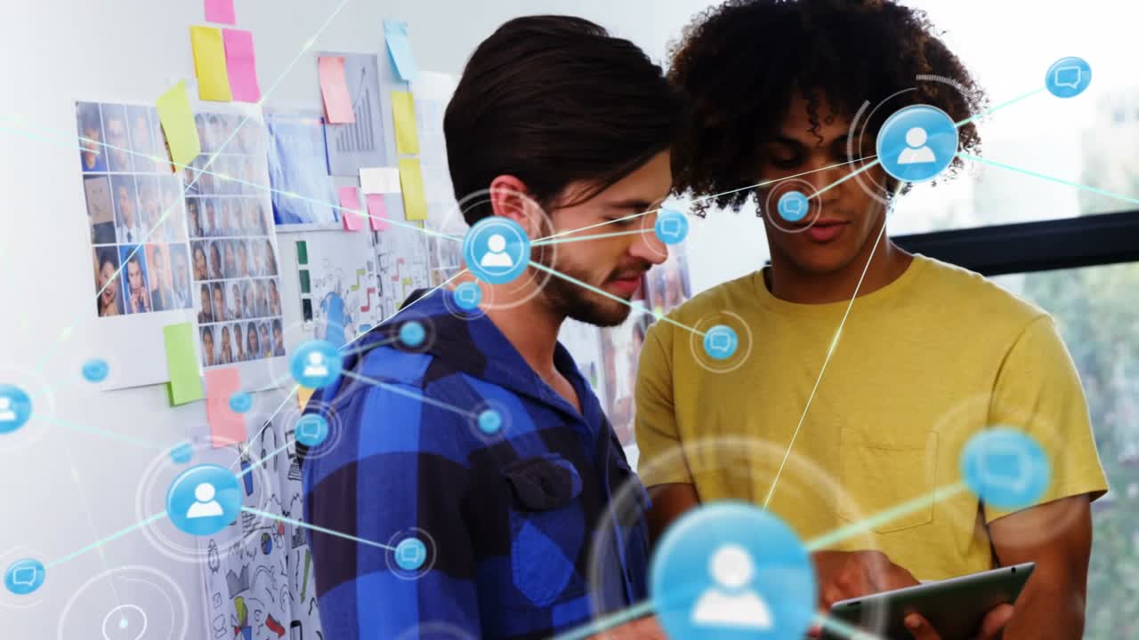 Animation of network of profile icons over two diverse men discussing over digital tablet at office