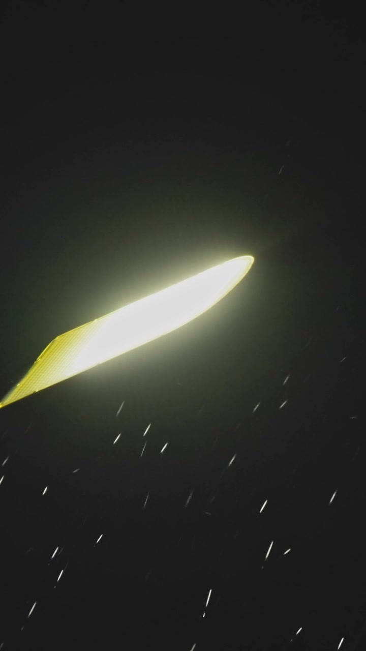 Pioggia che cade di notte sotto un lampione luminoso