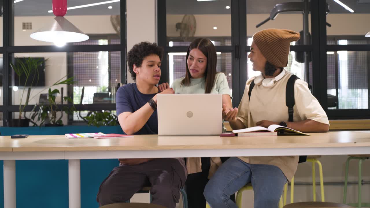 African American students, woman approaching laptop at lounge working together pointing high-fiving