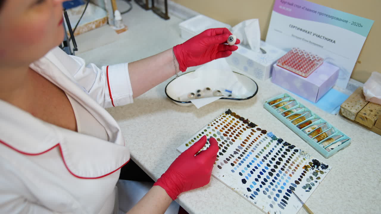 Glass made eye prosthesis. Eye prothesis in hand closeup