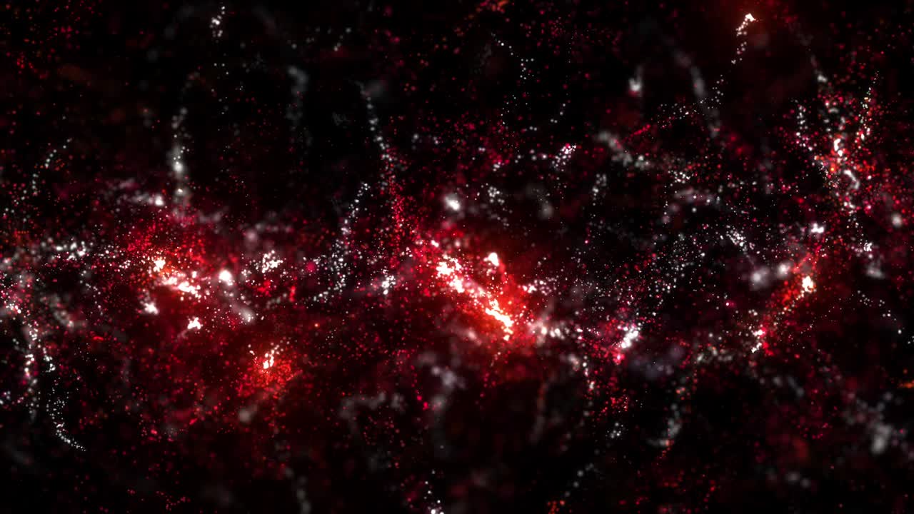 Red and white particles flowing on dark background with depth of field.