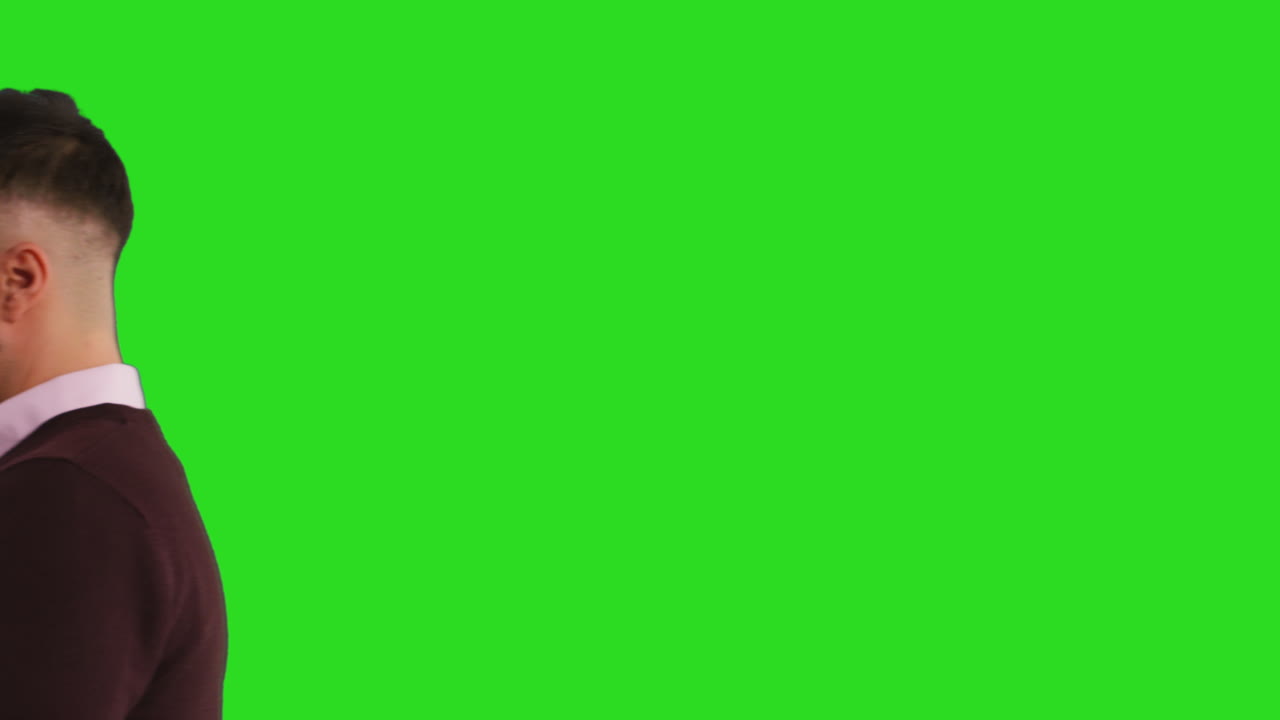 close up studio shot di un uomo d'affari che cammina usando il telefono cellulare per inviare messaggi o navigare online in piedi contro lo schermo verde 1