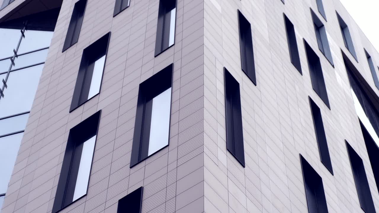 Low angle view of a grey building with multiple windows