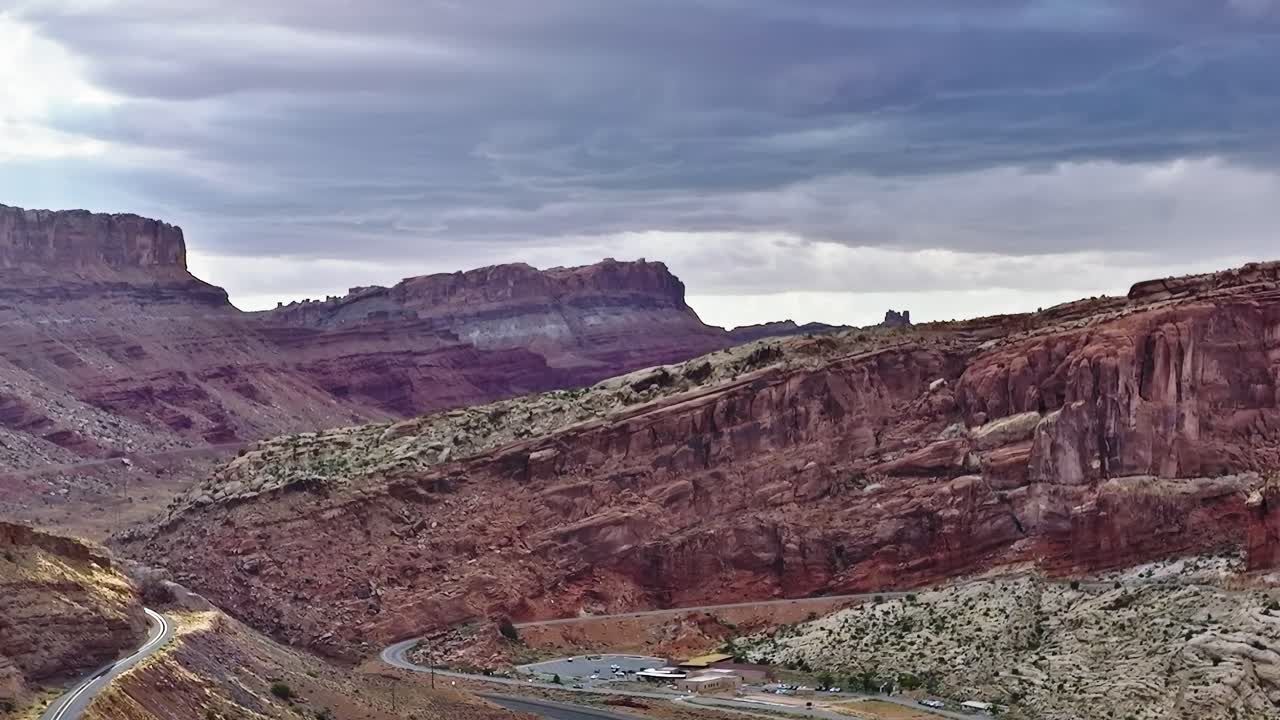 La valle di Moab nello Utah mostra una strada e formazioni rocciose sotto un cielo nuvoloso
