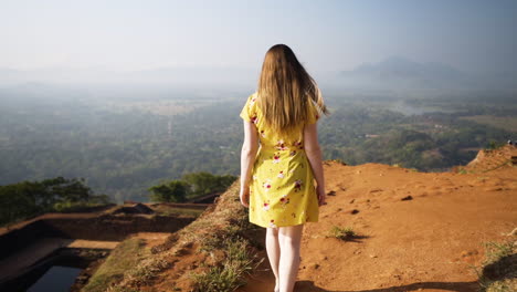 A-young-woman-walks-across-the-top-of-Lions-Rock-in-Sigiriya,-Sri-Lanka
