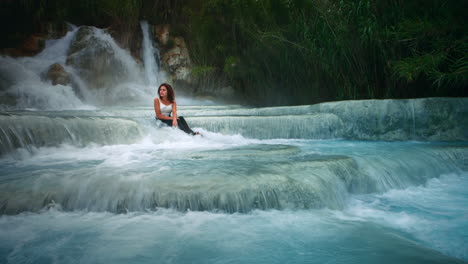 cinemagraph of a young woman sitting in thermal hot springs in saturnia, italy