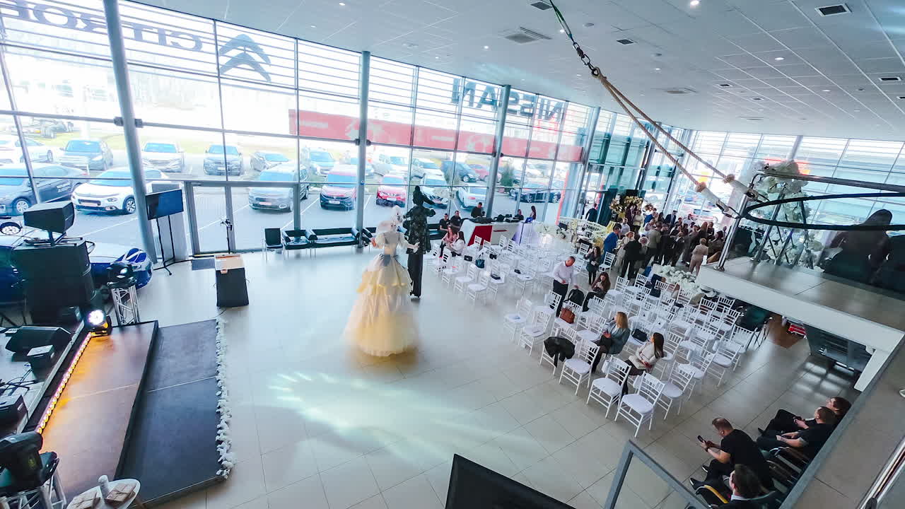 Show program in the light auditorium. The hall filling with people. People sitting on the chairs. Timelapse. Top view.