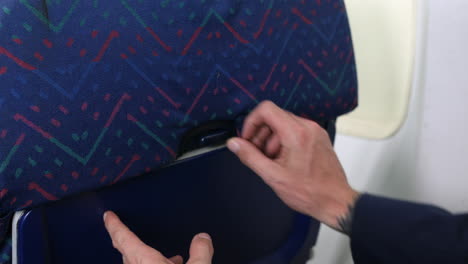 Close-up-of-opening-a-tray-table-on-an-airliner-airplane-seat