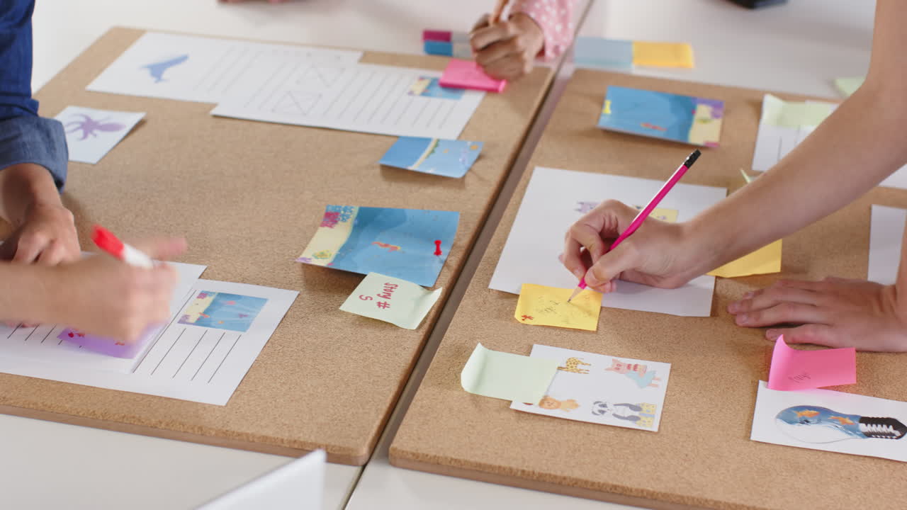 Collaborating in school, students brainstorming and writing ideas on sticky notes