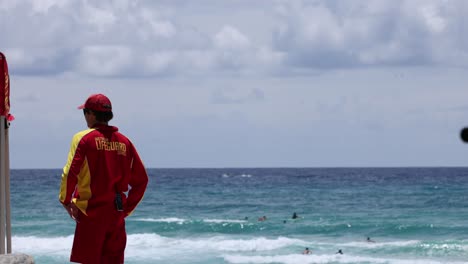 lifeguard in red uniform monitoring the ocean