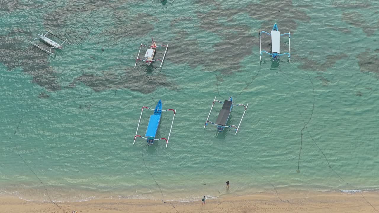 ターコイズブルーの海に浮かぶ伝統的なバリのジュクン船の空撮。
