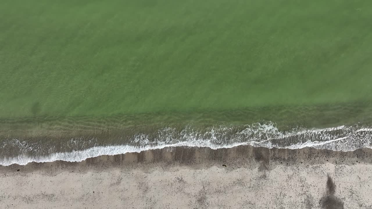 Aerial View of a Serene Beach with Calm Waves