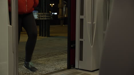 crowd of mixed people travelers entering finnish train at helsinki train station in the evening